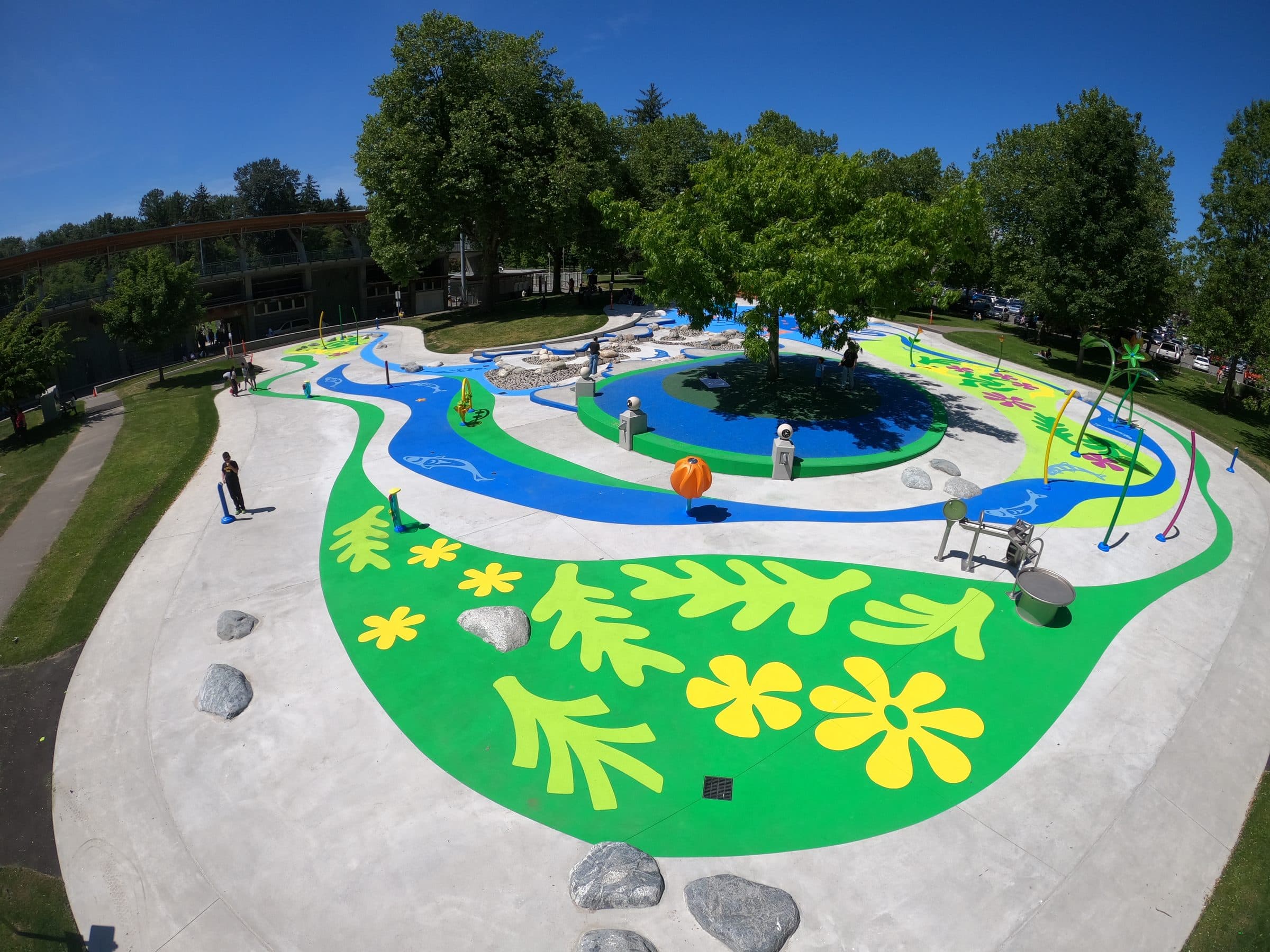 The Marine spray park in Surrey from above, a river of blue StreetBond winding through green leaves and yellow flowers