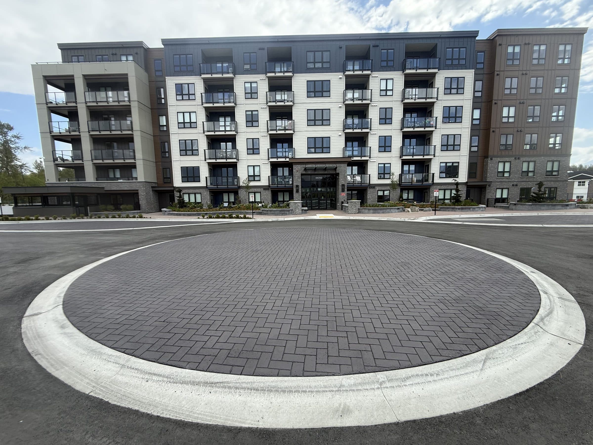 A circular turnaround in charcoal herringbone StreetPrint in front of a new apartment building in Chilliwack, installed by Square One