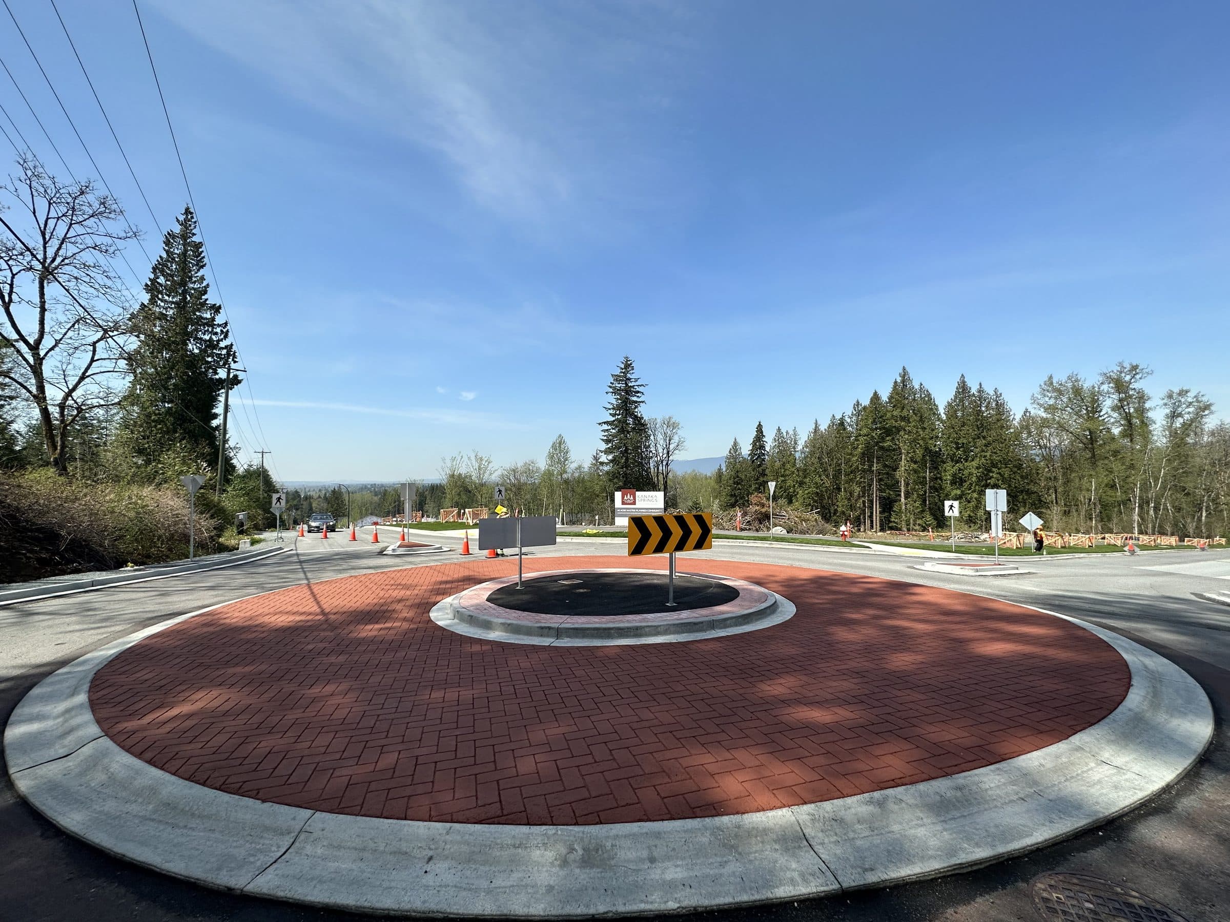 A brick-red StreetPrint roundabout apron under a clear sky in Maple Ridge, installed by Square One