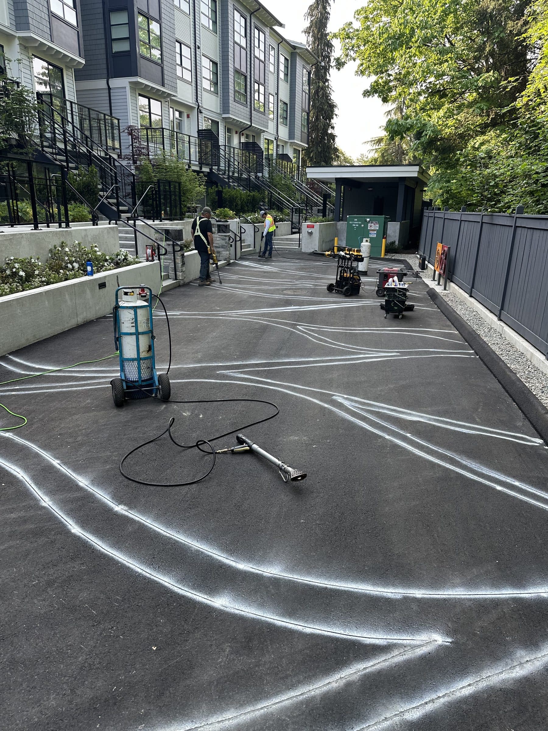 The template laid out in white on a townhouse laneway in North Vancouver before the asphalt is stamped